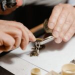 Detailed shot of a craftsman repairing a pocket watch using a magnifying tool on a workshop table.