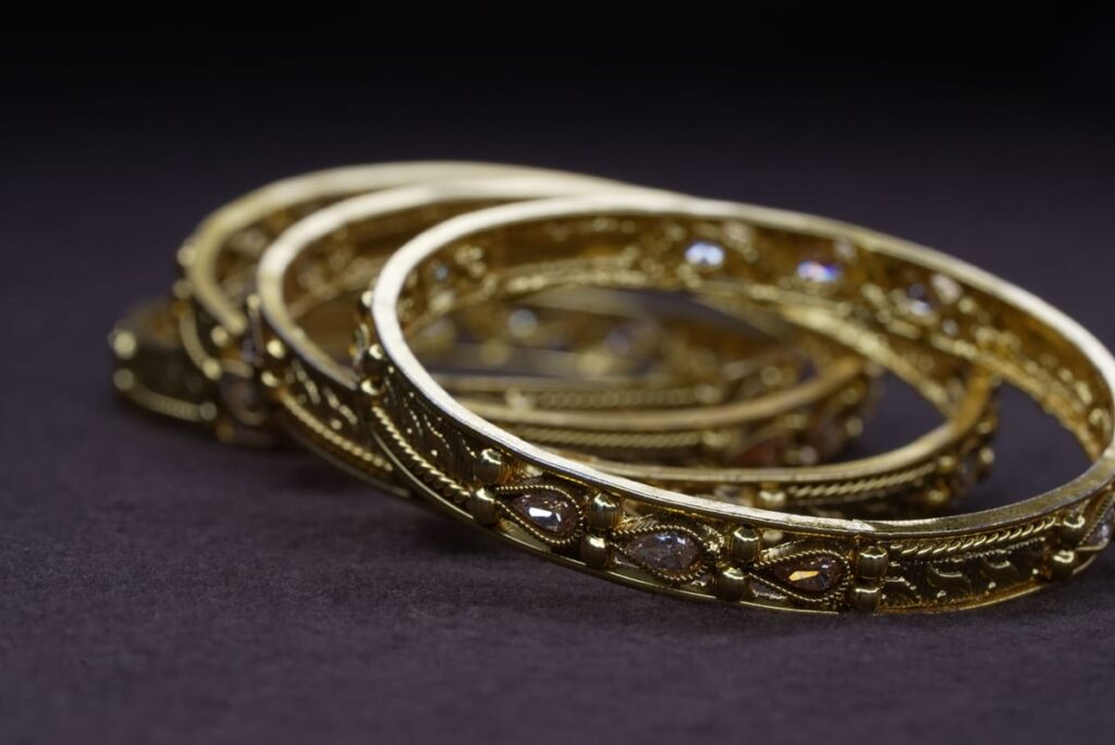 Bracelets dorés élégants avec motifs ciselés délicats, empilés et brillants sous la lumière